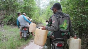Bentuk Kebersamaan TNI dan Rakyat Di Lokasi TMMD Bawa BBM Untuk Alat Berat