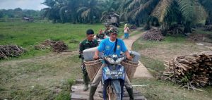 Lewati Jembatan Kayu, TNI Ini Bantu Warga Angkut BBM Untuk Alat Berat