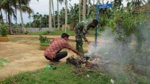 Anggota Satgas TMMD Di Sungaiterap Bantu Orang Tua Asuh Bersihkan Halaman Rumah 