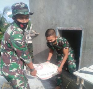 Bersama Warga, Anggota Satgas Bantu Angkut Semen Renovasi Masjid