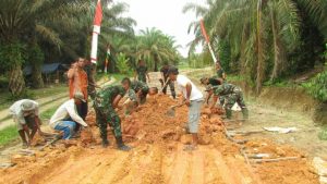 Satgas TMMD bersama Warga Gotongroyong Timbun Galar Jalan Di Desa Sungaiterap