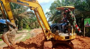 Serda Maryanto naik Ekskavator Awasi Pembangunan Jalan TMMD