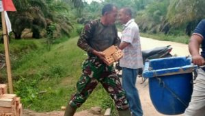 Kadus bersama Babinsa Bantu Langsir Batu Bata untuk Penahan Gorong – gorong