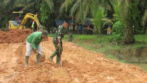 Bersama Warga, anggota Satgas TMMD Kuras Air Hujan Yang Banjiri Jalan Timbunan