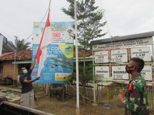 Anggota Satgas Bersama Warga Kibarkan Bendera Merah Putih di Kantor Desa