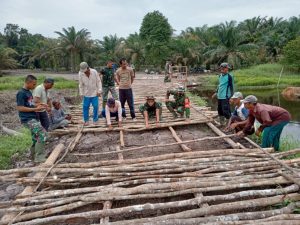 Warga Bersama Satgas TMMD Pasang galar Untuk Jalan Desa