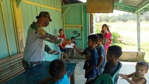 Anggota Kodim Sarko Bagikan Masker ke Anak-anak di Lokasi TMMD