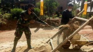 Satgas TMMD Bukitberingin Haluskan Pasir Untuk Plester Dinding MCK