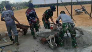 Bersama Warga, Satgas TMMD Gotong Royong Aduk Semen Cor Lantai Pos Jaga