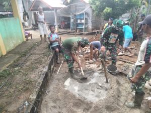 TNI Bersama Warga Gotong Royong Aduk Semen dan Pasir untuk Pondasi MCK Madrasah di Desa Bukit Beringin