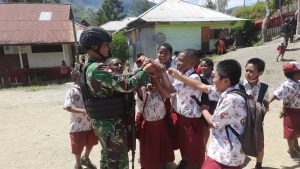 Satgas Pamtas Yonif Raider 142/KJ Bagikan Tas Sekolah untuk Anak SD Negeri Karubaga