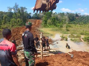 Satgas TMMD Ke-117 Bersama Masyarakat Desa Talang Silungko Pasang Kayu Cerucuk Untuk Jembatan