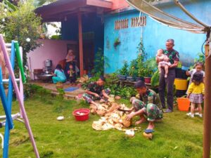 Anggota Satgas TMMD Bantu Orang Tua Asuh Mengupas Kelapa