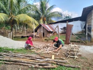 Anggota Satgas TMMD Ke-117 Bantu Orang Tua Asuh Belah Kayu Bakar Untuk Memasak