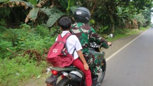 Bantu Kesulitan Warga Desa, Anggota Satgas TMMD Kodim 0416/Bute Antar Anak Pulang Sekolah