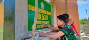 Anggota Satgas TMMD Cat Papan Nama SD Negeri 57/II Talang Silungko Penuh Warna