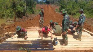 Teriknya Matahari Tak Mengurangi Semangat Satgas TMMD dan Warga Talang Silungko Membangun Jembatan