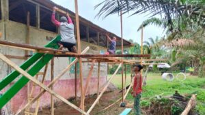 Semangat Gotong Royong, Warga dan Satgas TMMD Ke-123 Pasang Lisplang Madrasah di Teluk Kuali